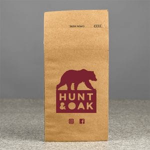PB Print Printed Paper Bags A white paper bag with custom subtle branding in dark green, emphasizing a stylish design and durable material.